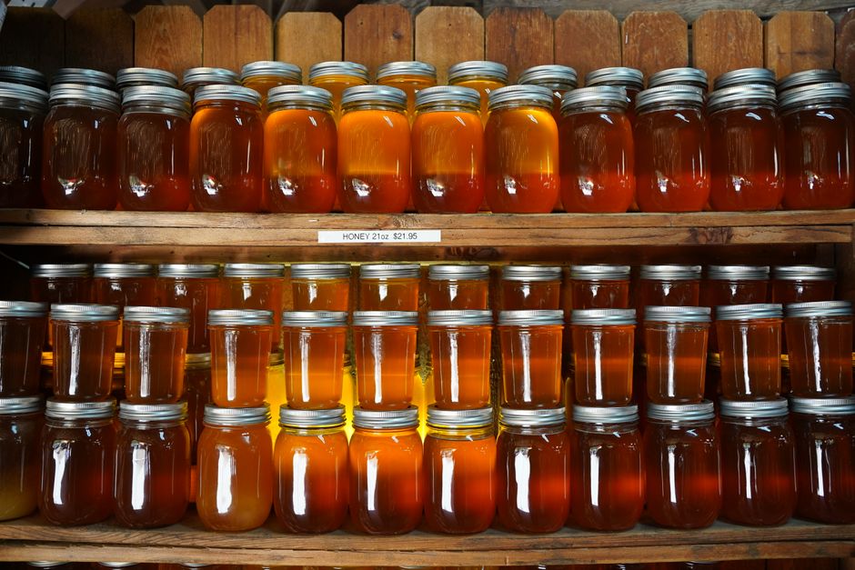 Výrobní dílna, sklenice na lince, ruce plnící kimchi do sklenic